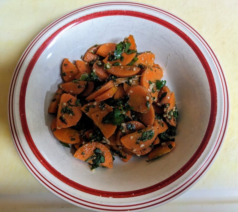 Bowl of steamed carrots with herbs and spices